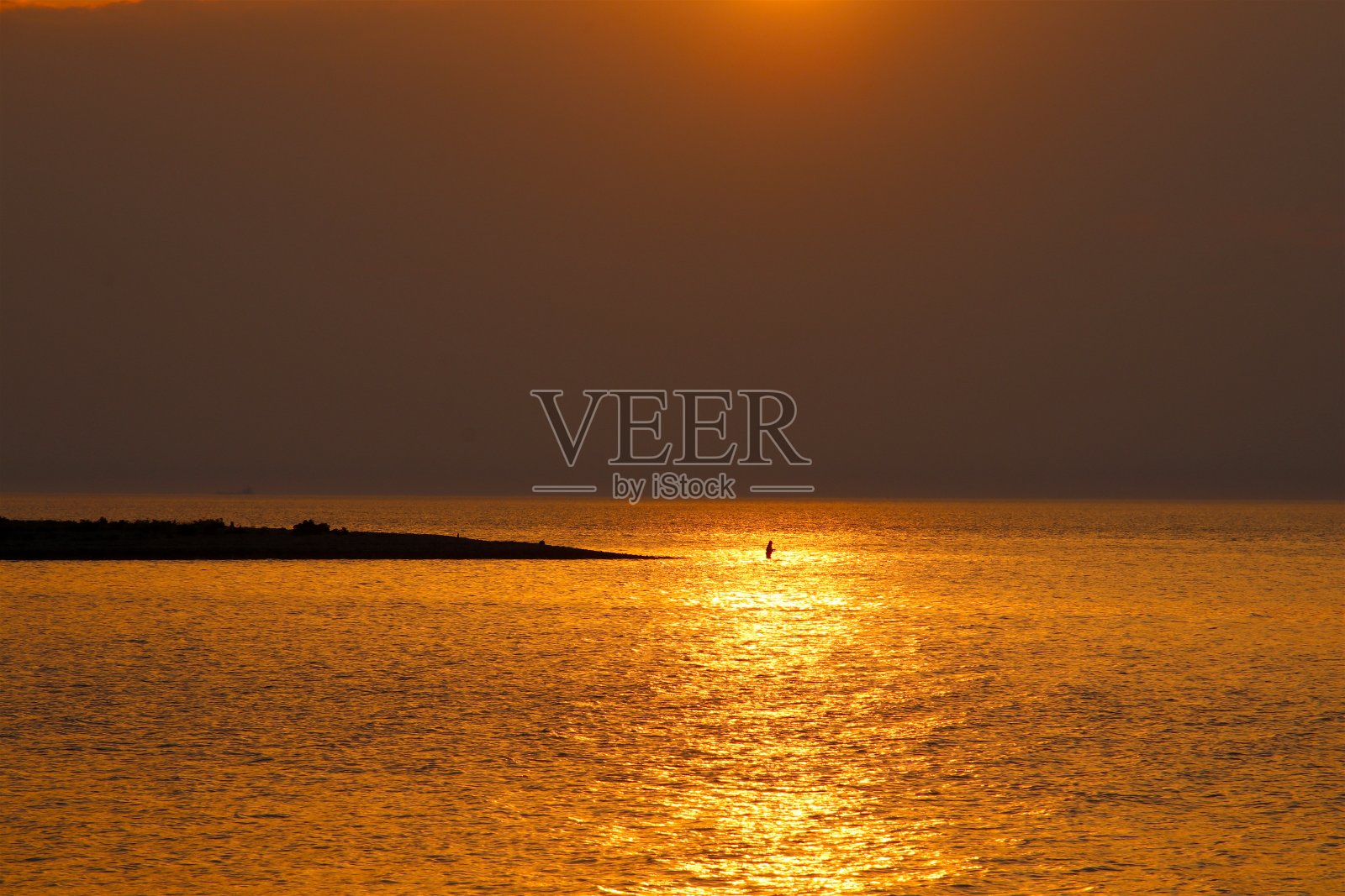 夕阳下，在金色的大海里垂钓照片摄影图片