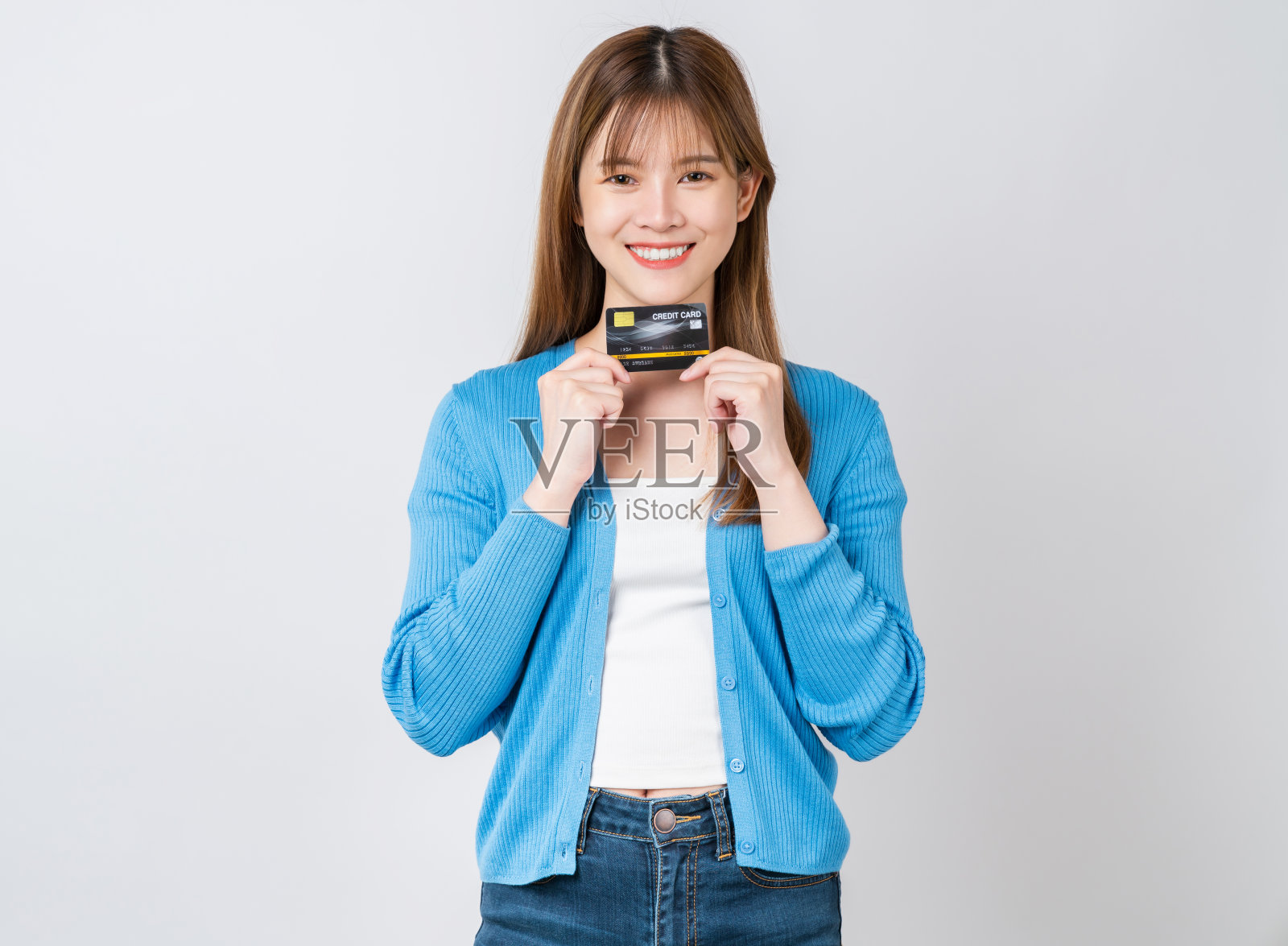 开朗美丽的亚洲女人拿着白色背景的信用卡模型。照片摄影图片