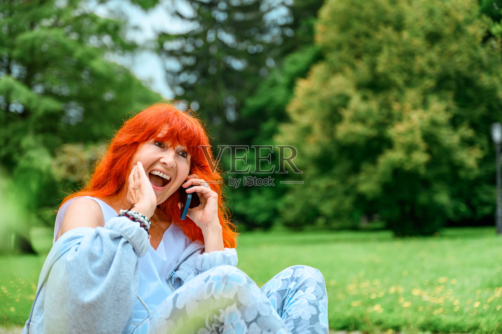 一位老妇人在公园里使用手机照片摄影图片