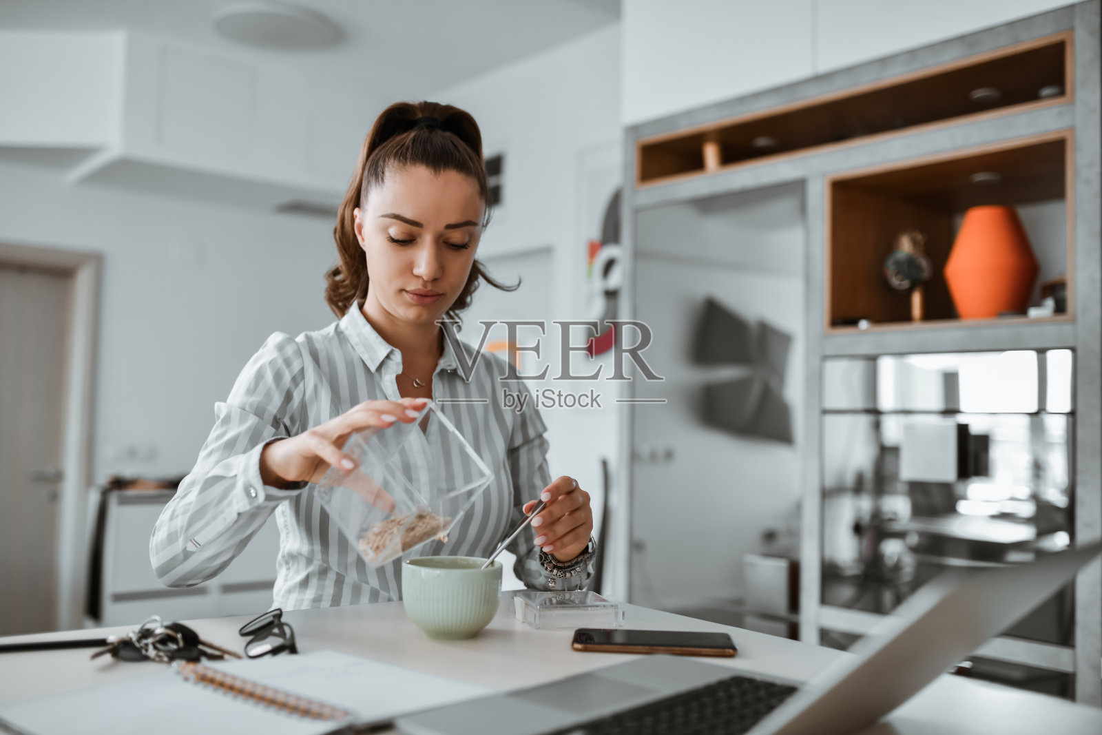 女社交媒体经理在家工作时给自己做燕麦片照片摄影图片