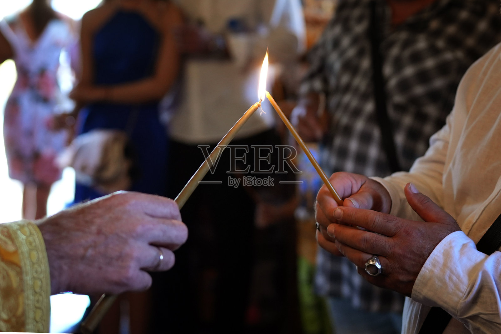 牧师在教堂里点燃蜡烛的手照片摄影图片