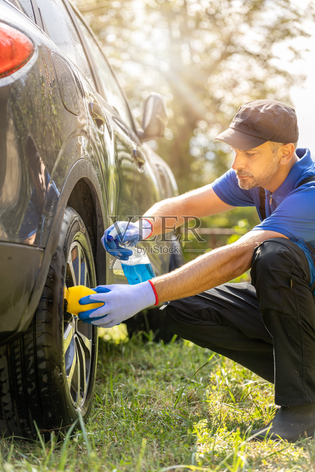 工人清洗汽车合金车轮。照片摄影图片