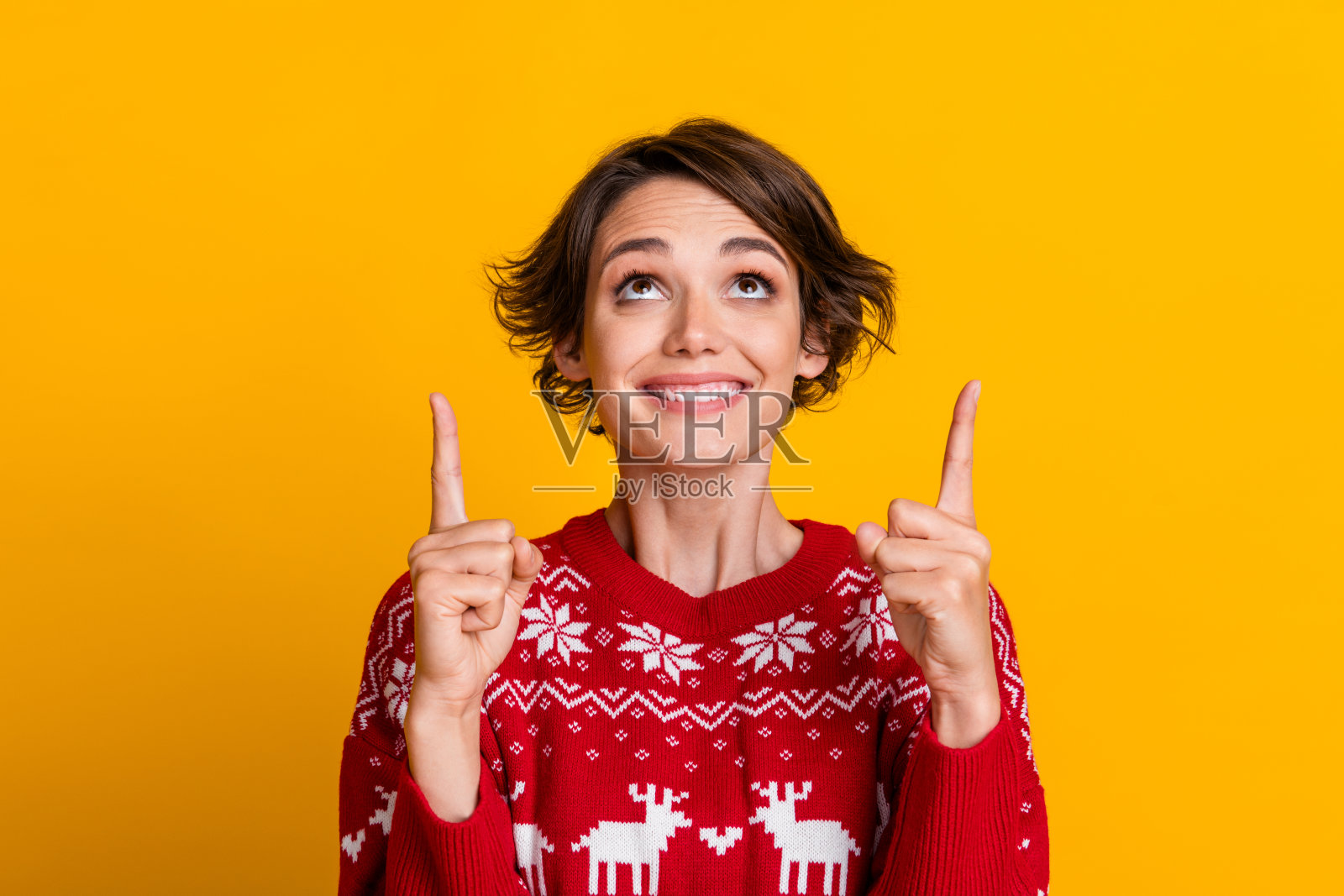 照片中心情好的女孩梳着鲍勃发型，穿着红色运动衫，看起来像是在黄色背景上孤立的空空间照片摄影图片