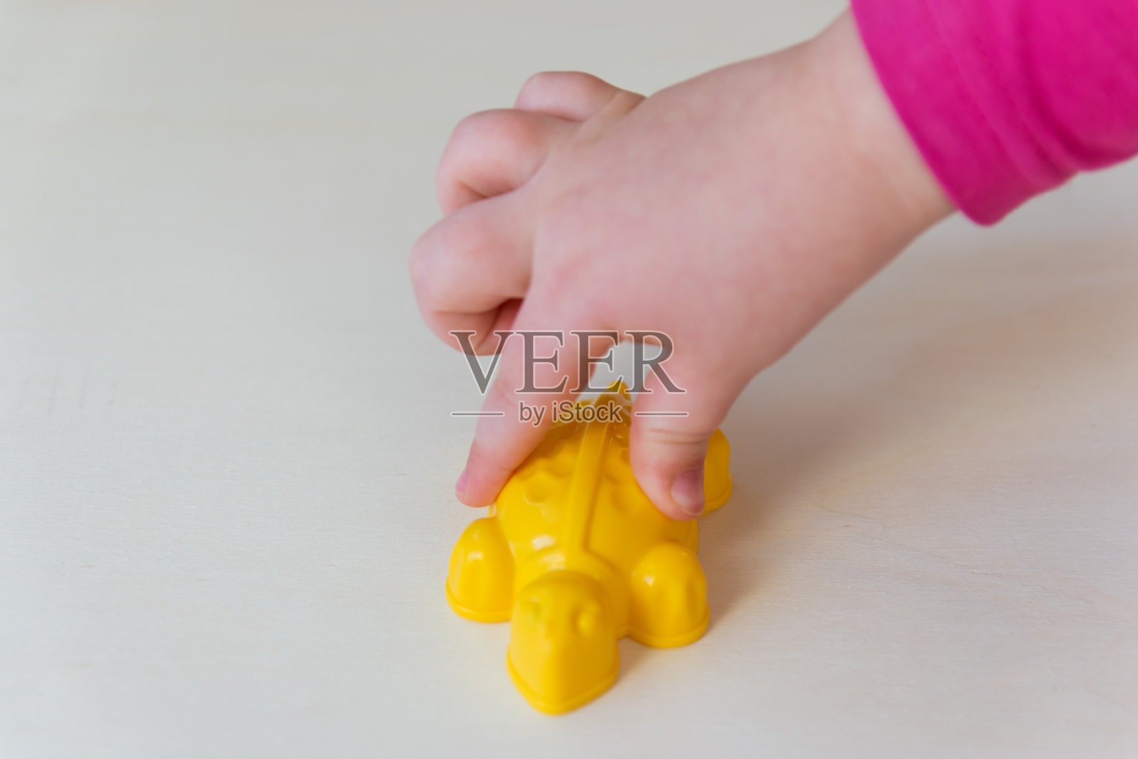 孩子展示手里的小塑料玩具。照片摄影图片