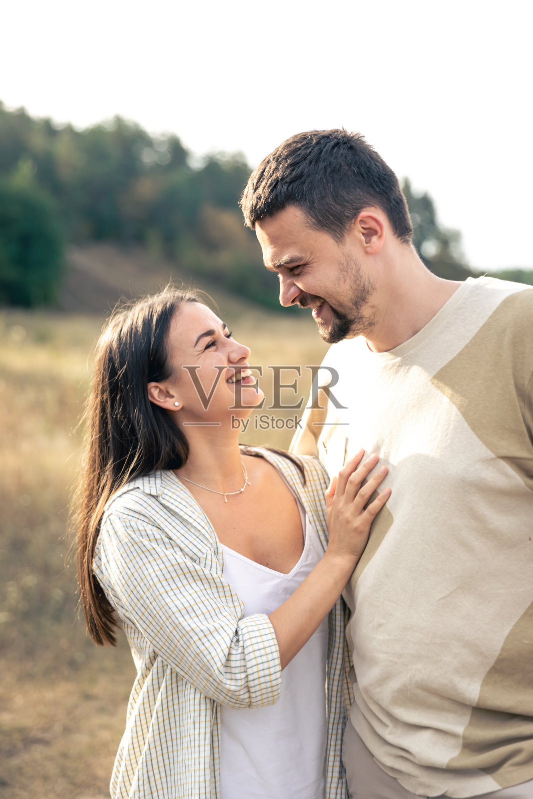 一个男人和一个女人走在田野里，一对幸福的夫妇。照片摄影图片