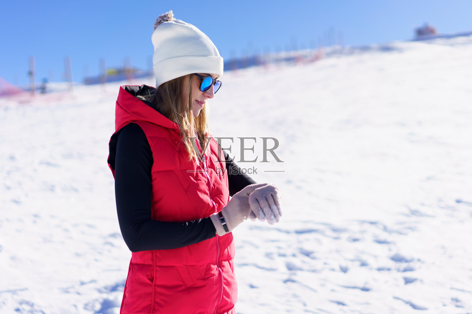 快乐的年轻女子站在那里查看手表的时间照片摄影图片