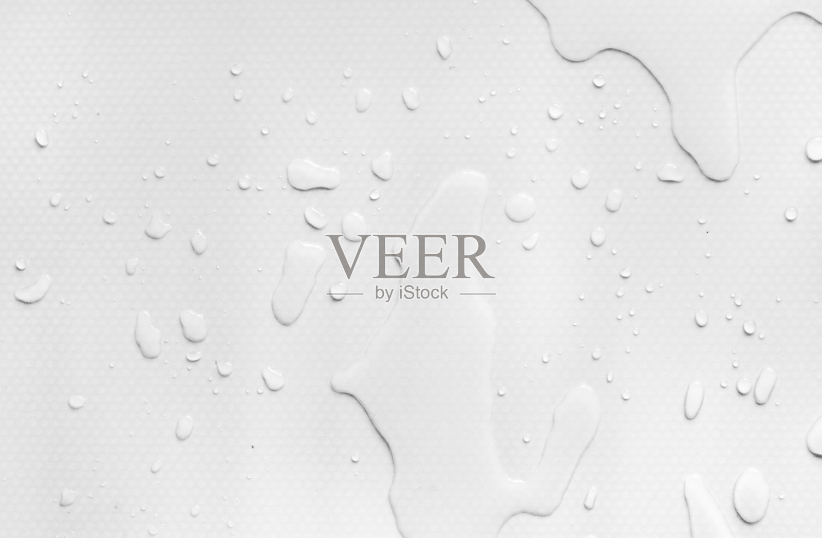 水滴在白色的背景上。把水洒在桌子上了。照片摄影图片