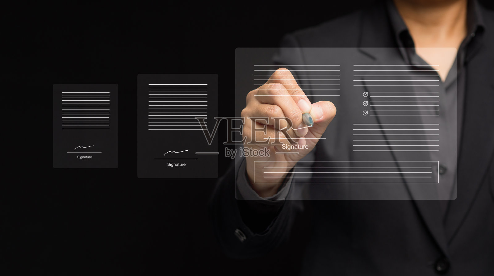 商人站在黑色背景上，用一支笔在虚拟屏幕上签署电子文件照片摄影图片