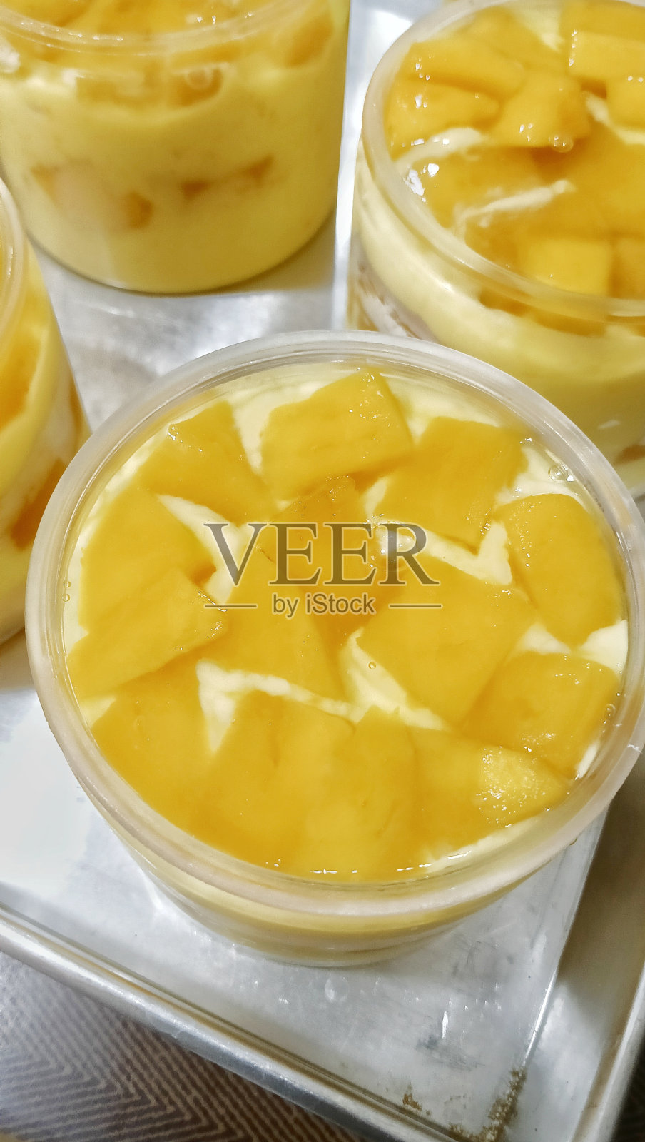 罐装奶油芒果甜点。照片摄影图片