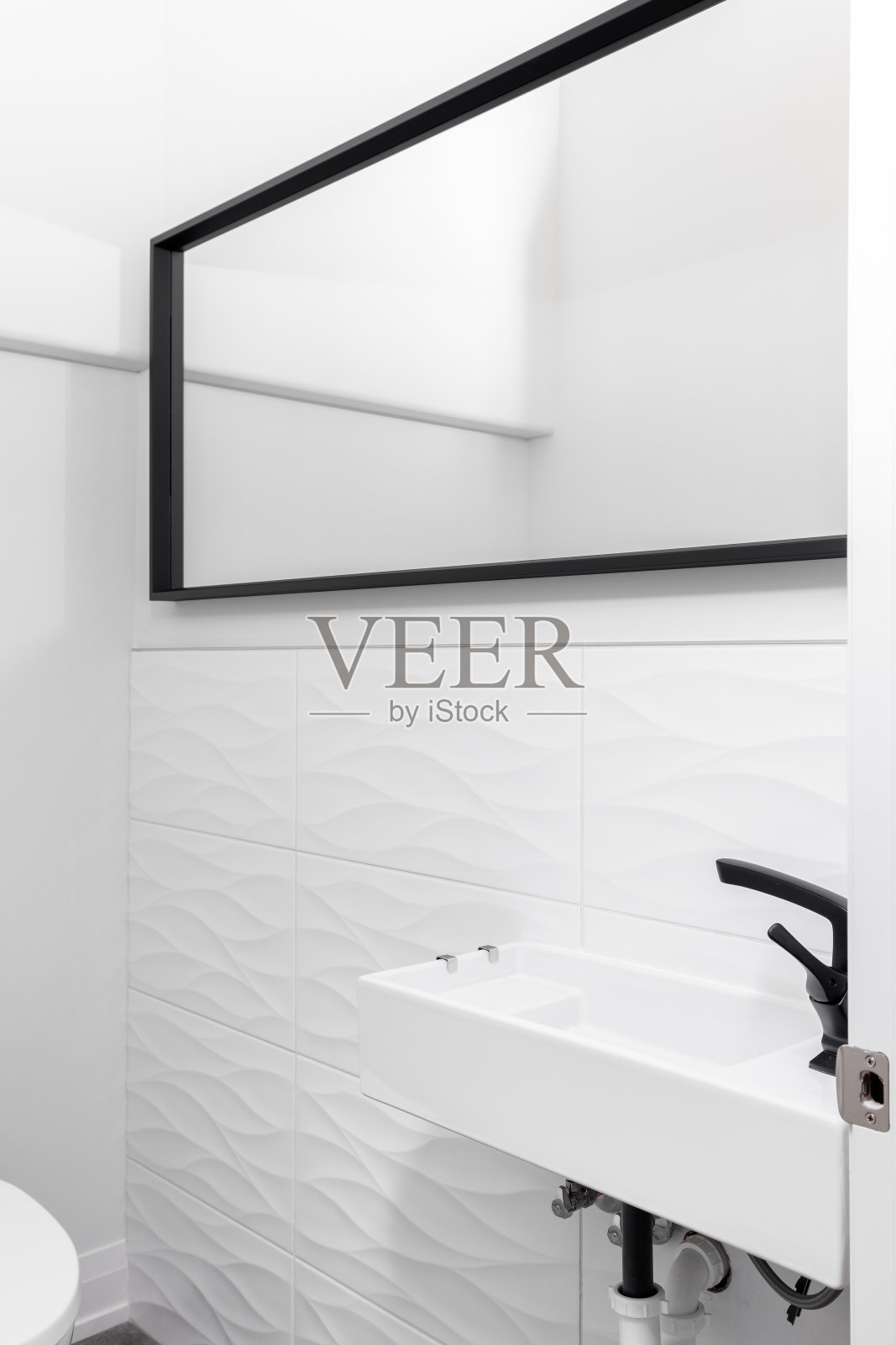 一间小浴室，墙上贴着白色波浪形瓷砖。照片摄影图片