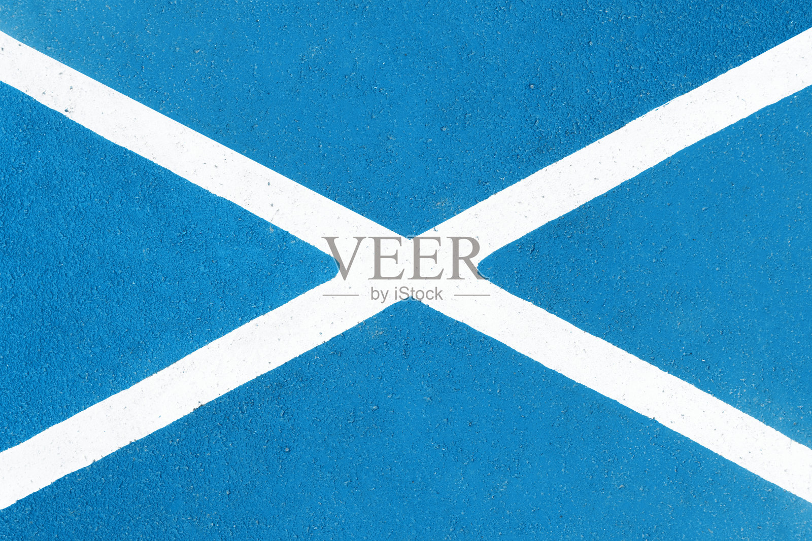 在沥青上油漆。白色X形。蓝底白线。泊车位已标示。禁止停车。照片摄影图片