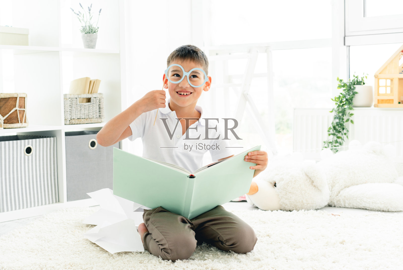 快乐的男孩戴着眼镜读书照片摄影图片