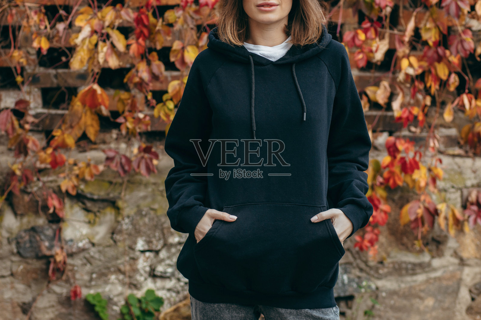 戴眼镜，穿黑色连帽衫的年轻女子照片摄影图片