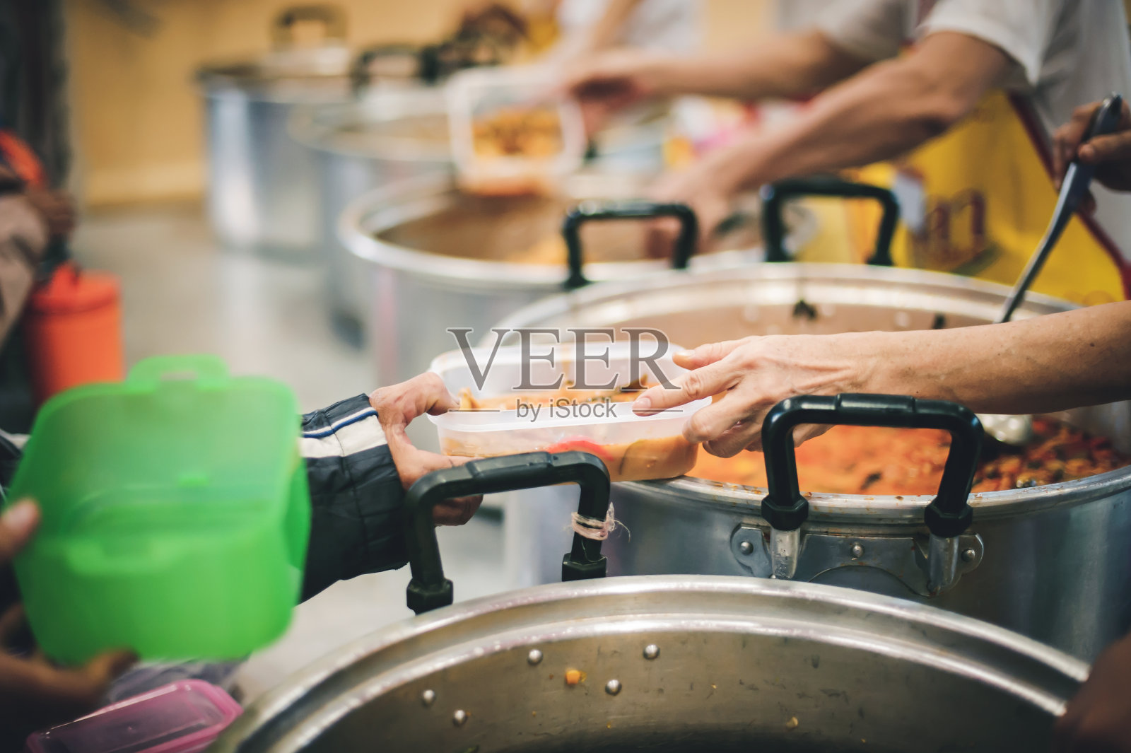 志愿者给有需要的人食物，分享食物以减少饥饿照片摄影图片