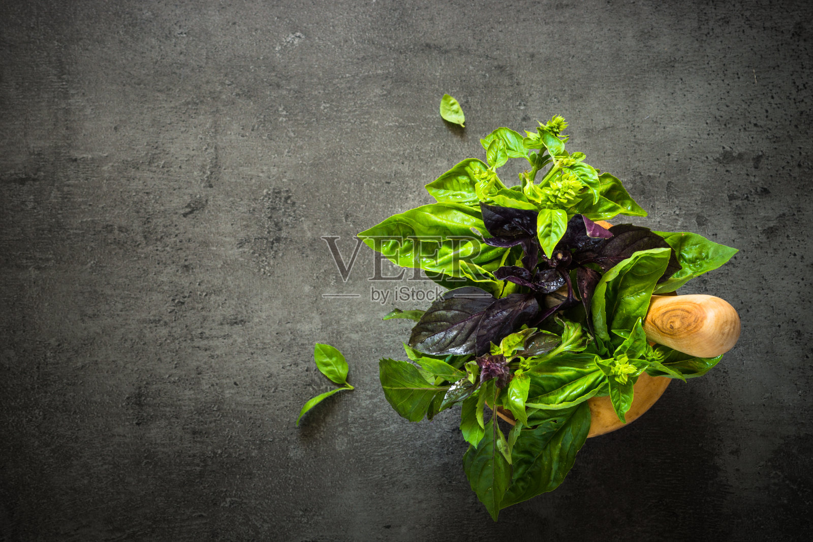 把罗勒放在研钵里，调成黑色。照片摄影图片