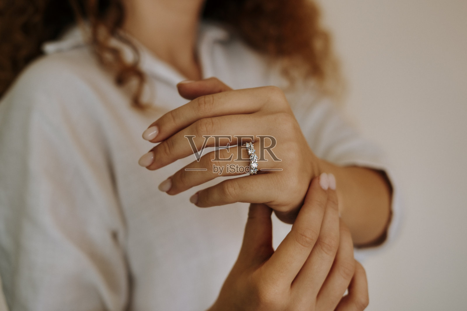 手指上戴着钻戒的女人。照片摄影图片