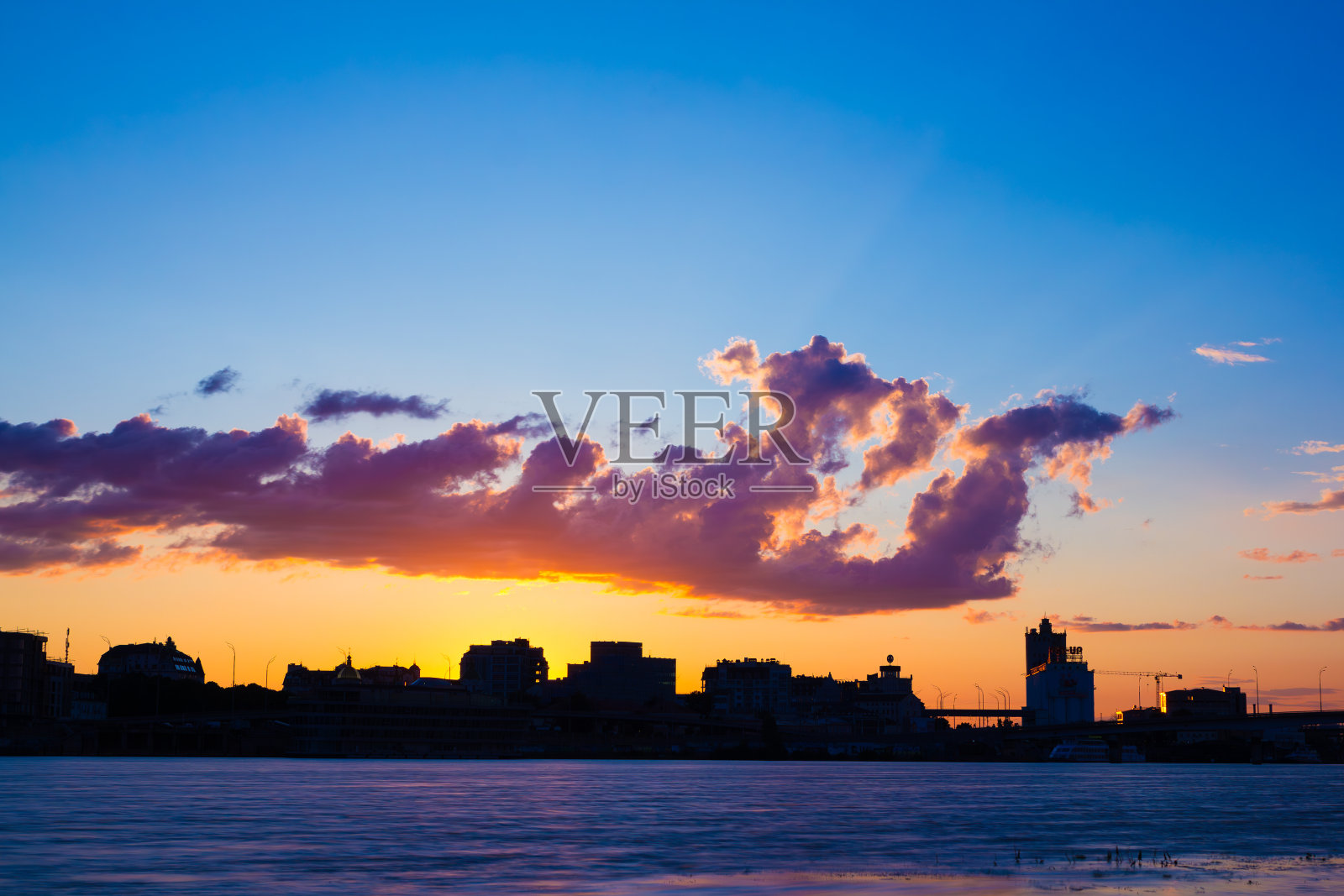 宁静的黄昏:落日在城市和河流上照片摄影图片