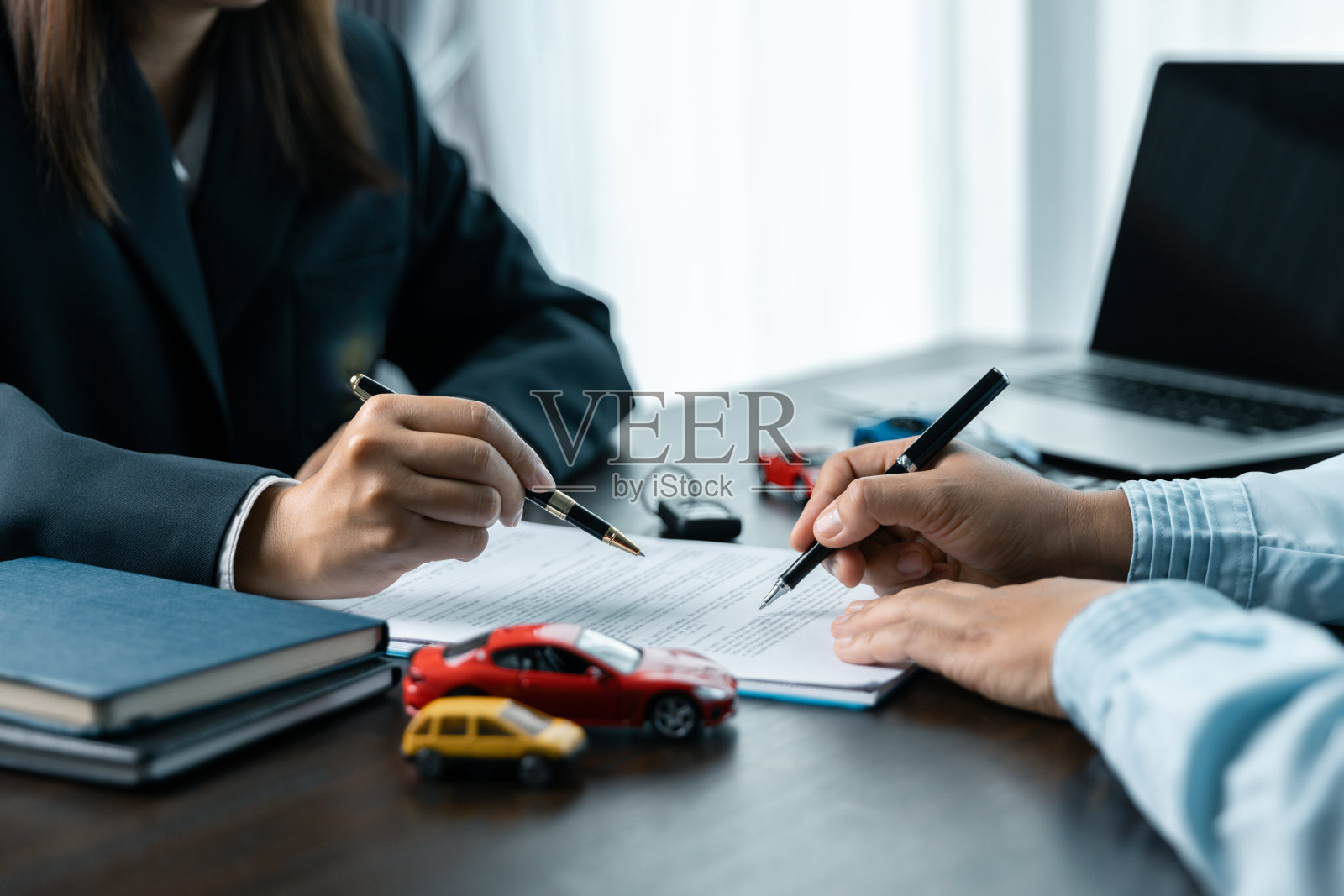 亚洲人汽车销售员或销售经理提供汽车销售，并解释和阅读签订汽车合同和保险的条款。汽车经销商和保护，以防止损坏和风险驾驶。照片摄影图片