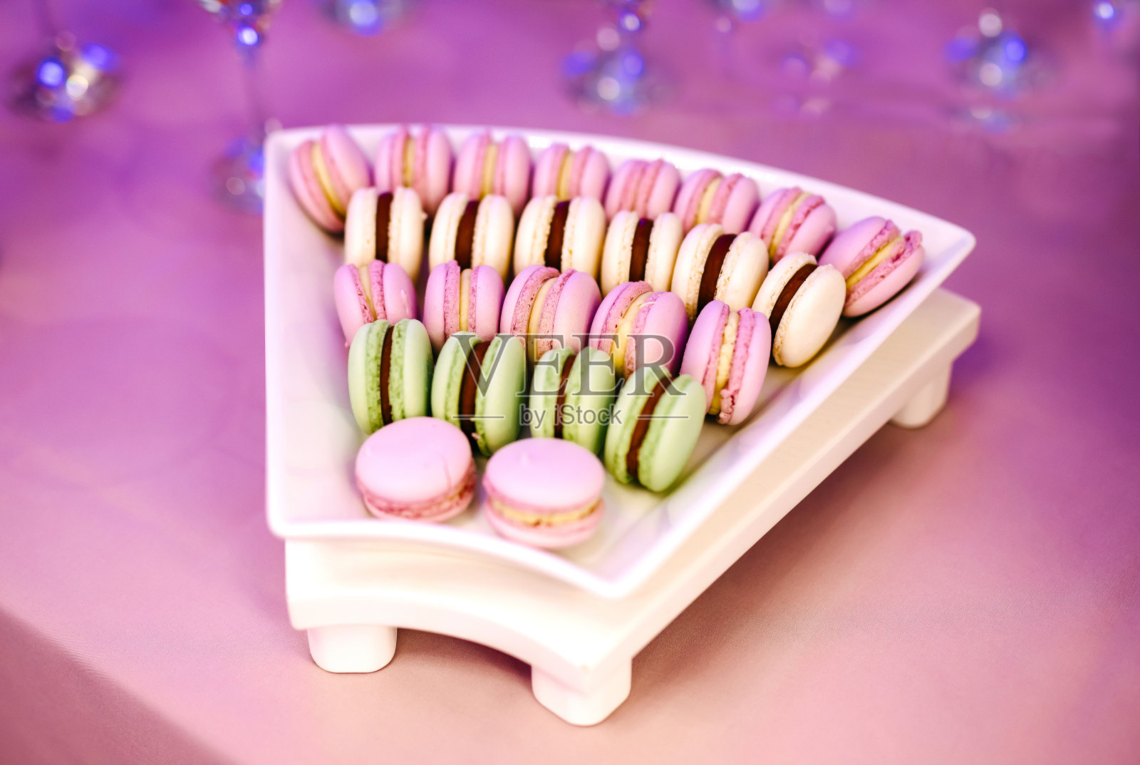 Colorful macaron stack on a white plate照片摄影图片