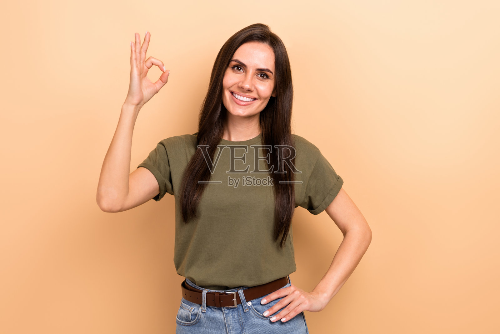 照片的好心情积极的女人直发穿着卡其布t恤显示好的不错的工作孤立的米色背景照片摄影图片