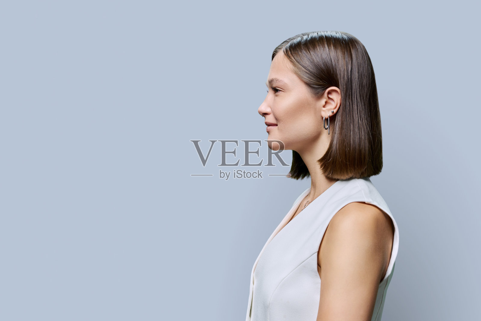 年轻时尚女子的侧面视图与灰色背景照片摄影图片