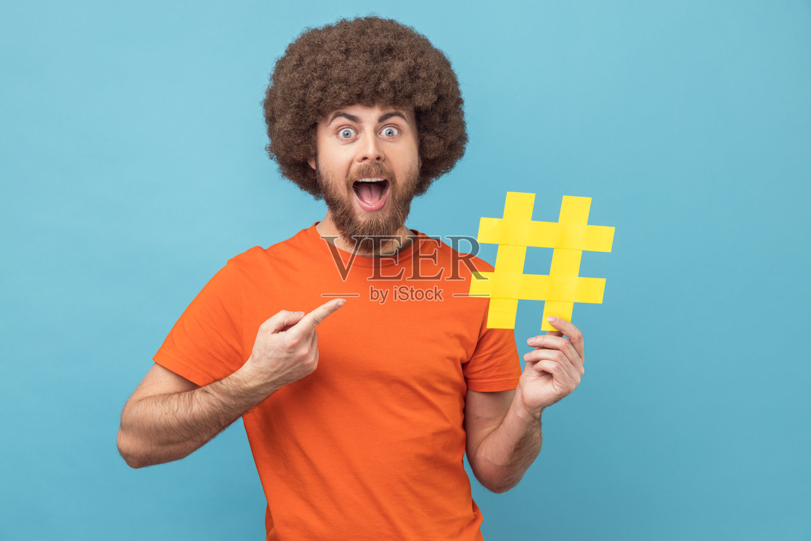 一名男子微笑着指着黄色的标签符号，这是互联网趋势的标志。照片摄影图片