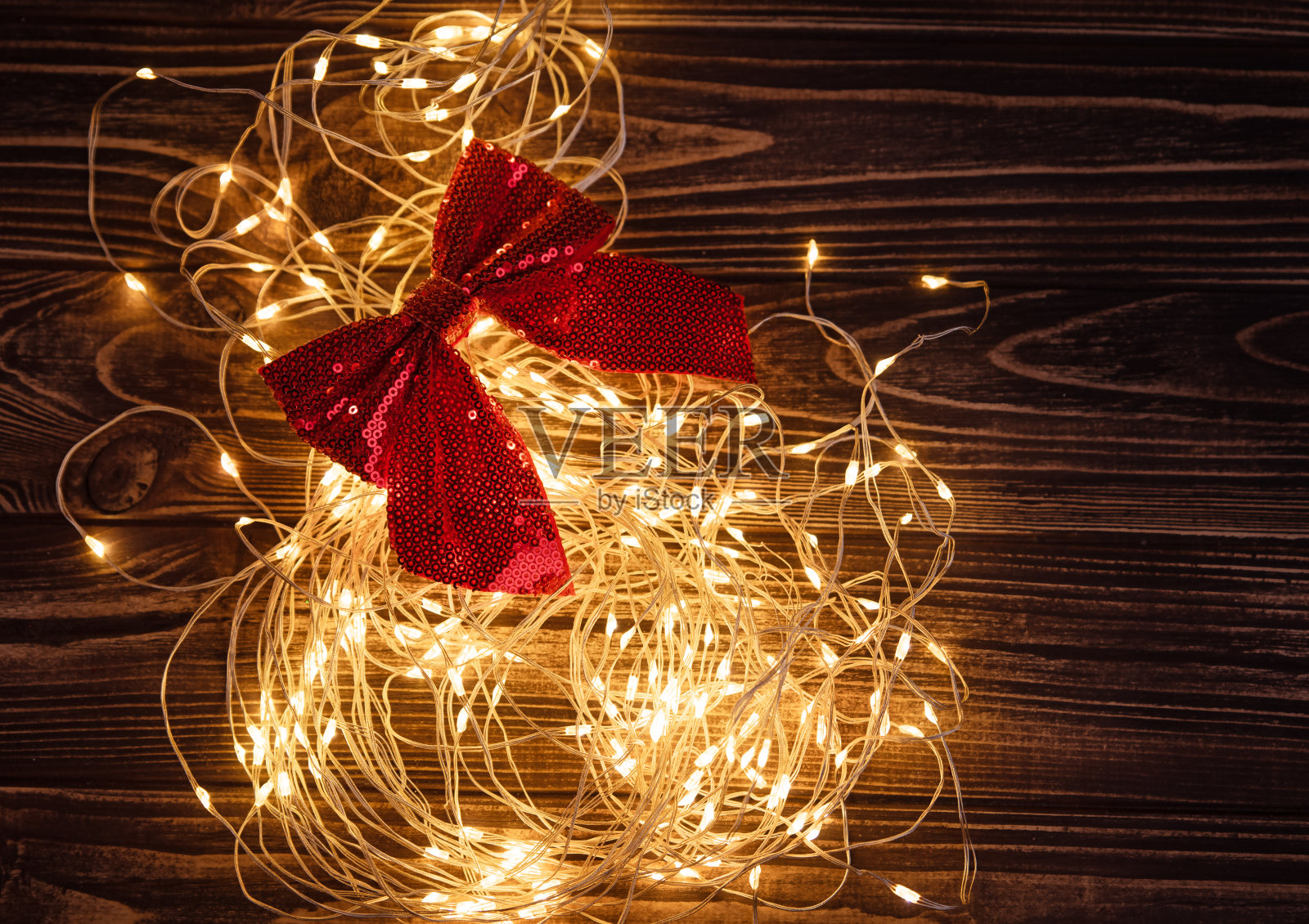 木制背景上的黄色暖光花环照片摄影图片