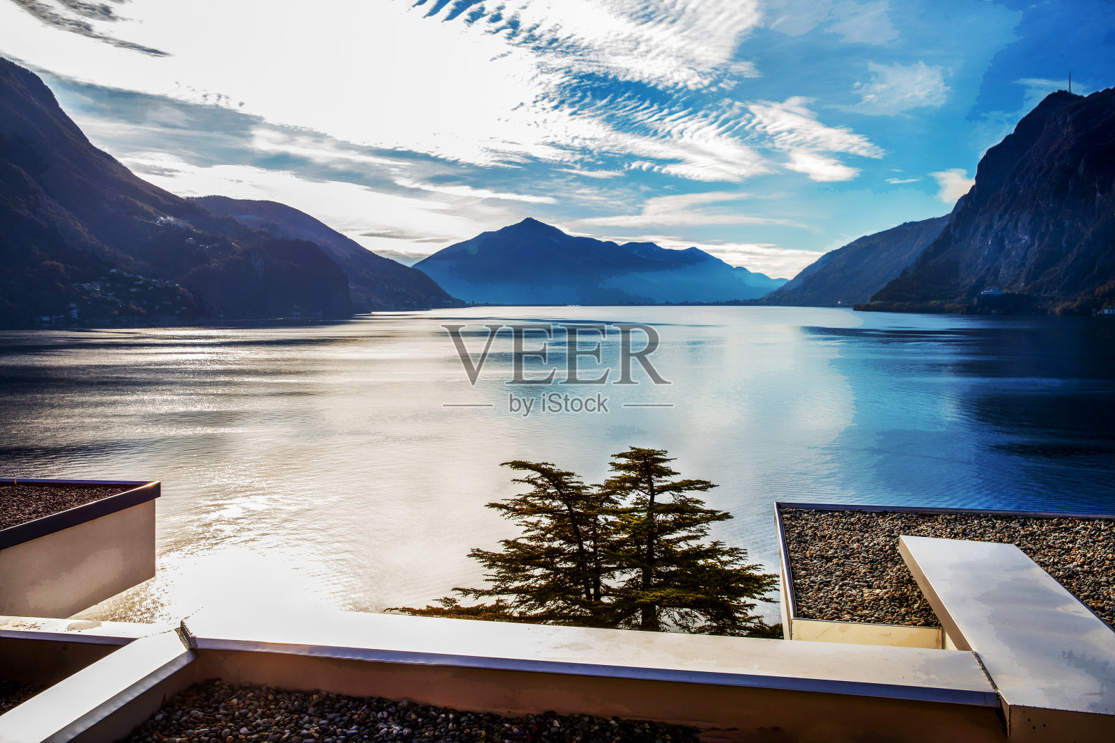 卢加诺湖的全景，瑞士阿尔卑斯山和皮划艇在水中移动照片摄影图片