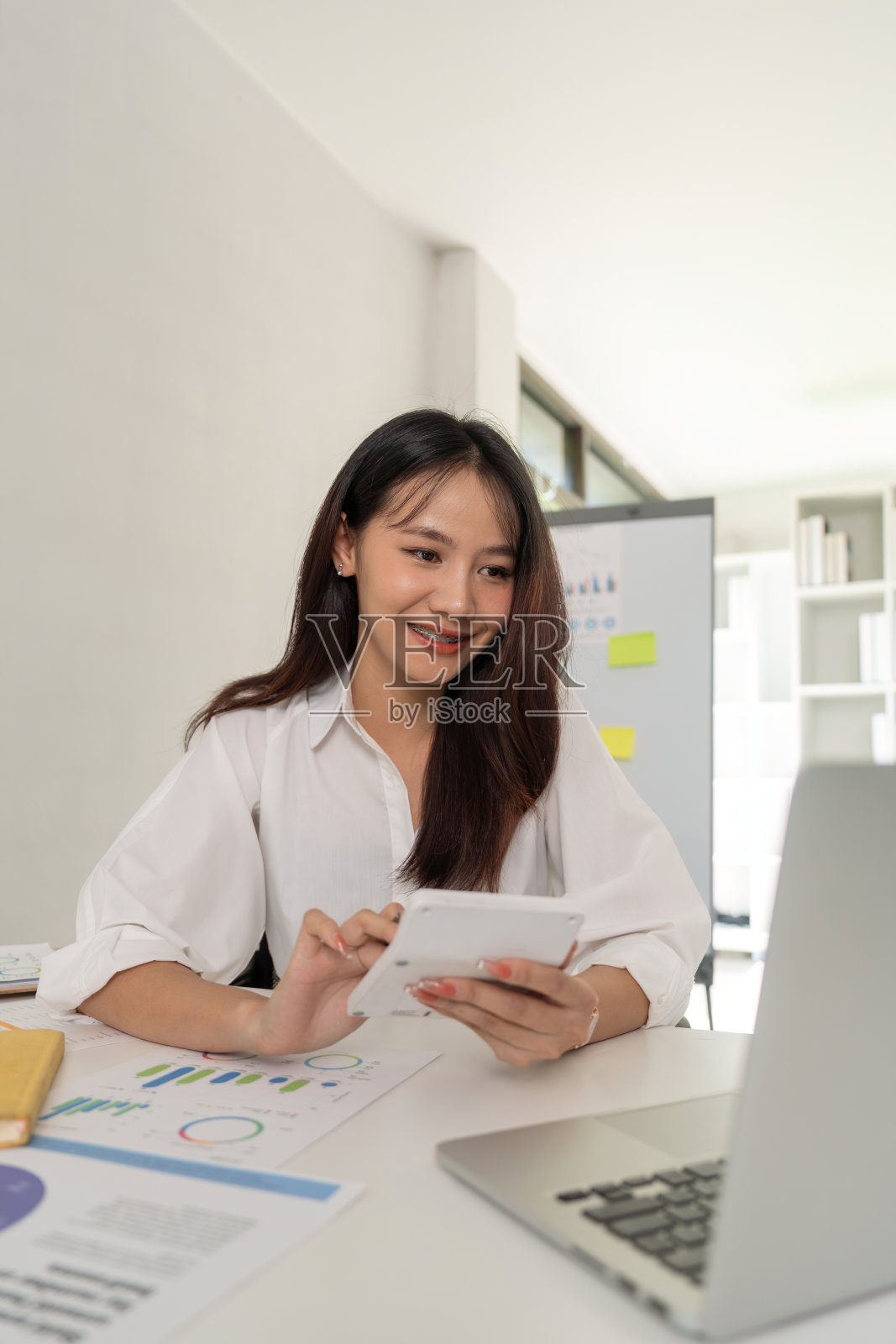 商务女会计使用计算器和笔记本电脑在办公室保存财务数据，商务财务，税务，会计概念照片摄影图片