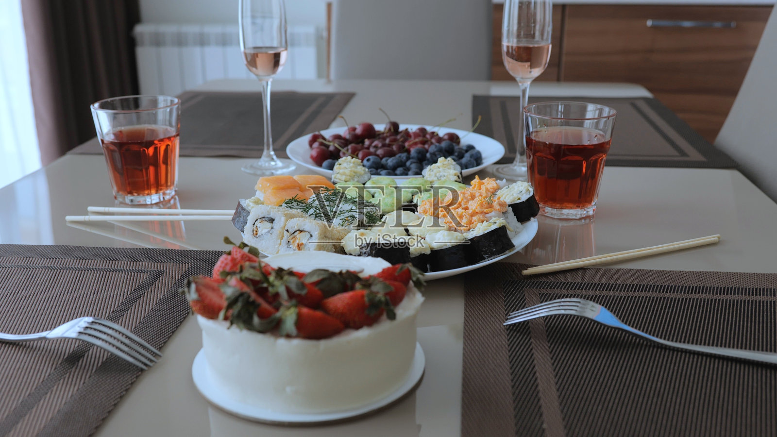 大量的食物种类和选择，以及寿司与水果和甜点。白色盘子里摆着各式各样的寿司。两个人的晚餐，有寿司和红酒。照片摄影图片