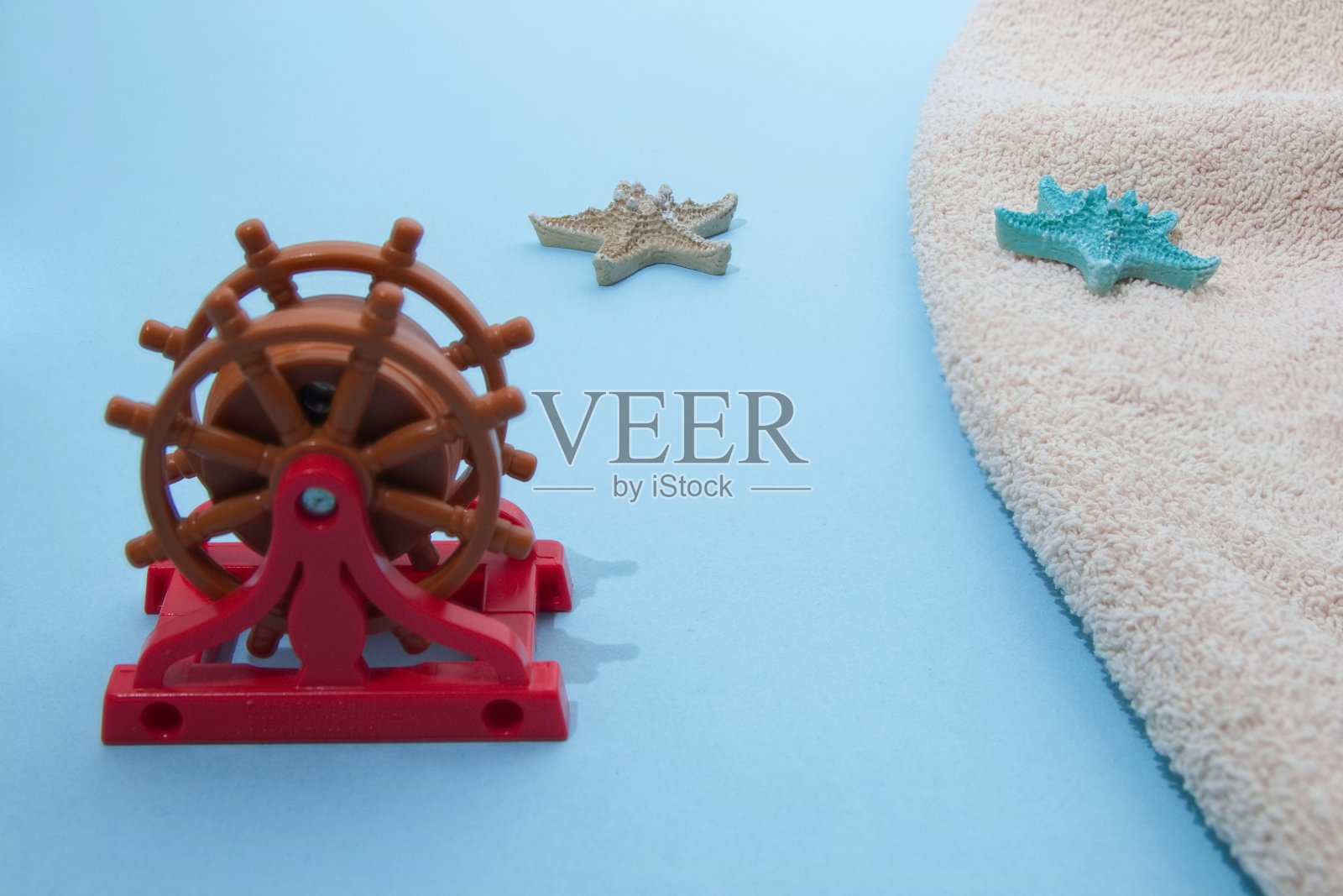 在海上掌舵，在水上和陆地上都有海星。极简的夏日场景。照片摄影图片