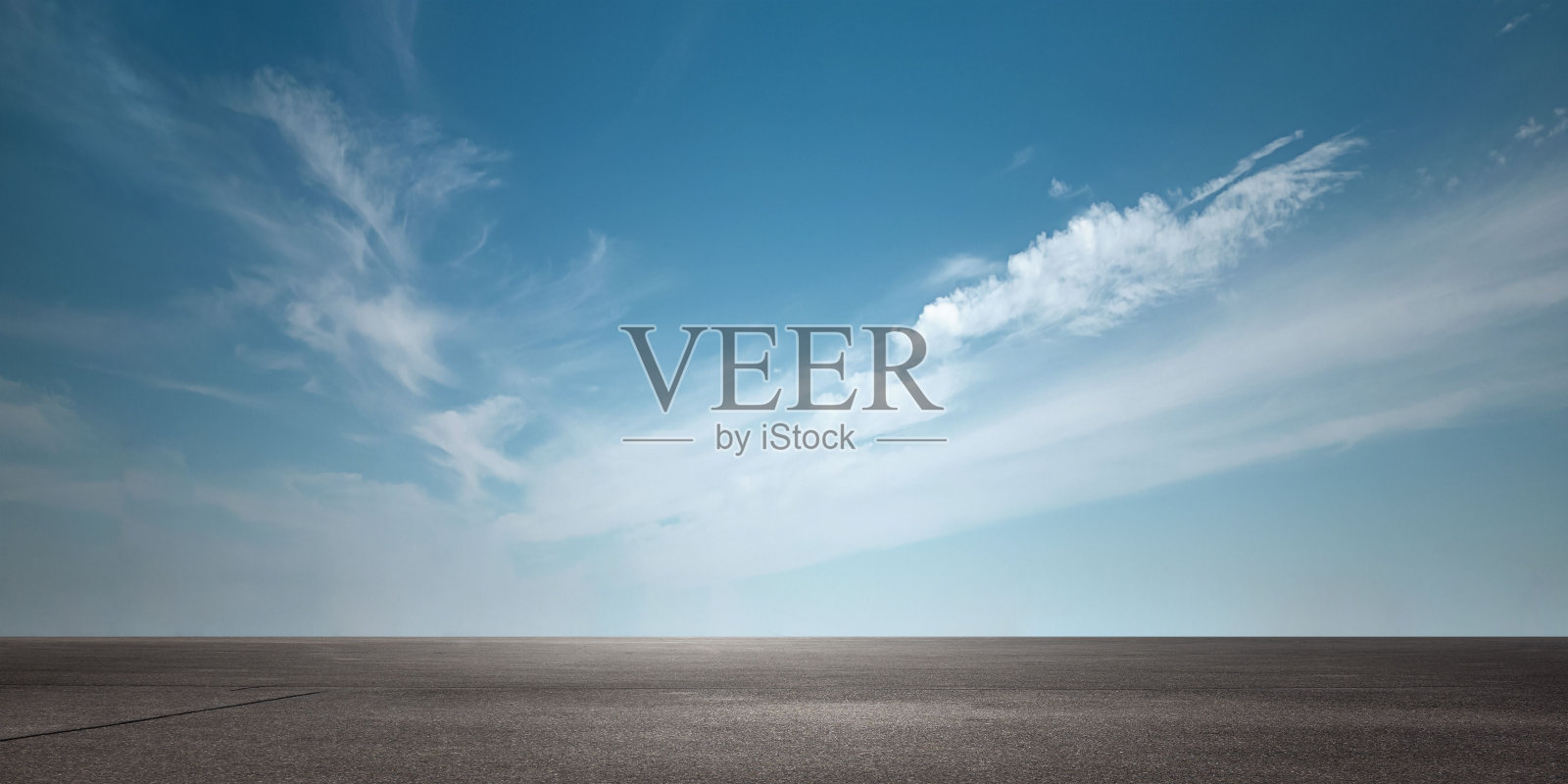 令人惊叹的多云的天空，蓝色的阴影，在柏油路上照片摄影图片