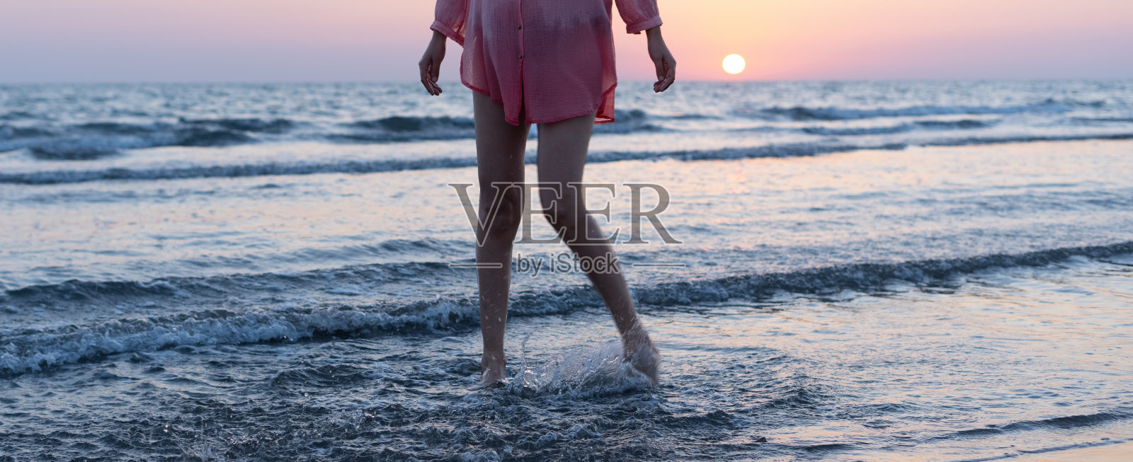 夕阳下沙滩上的女人照片摄影图片