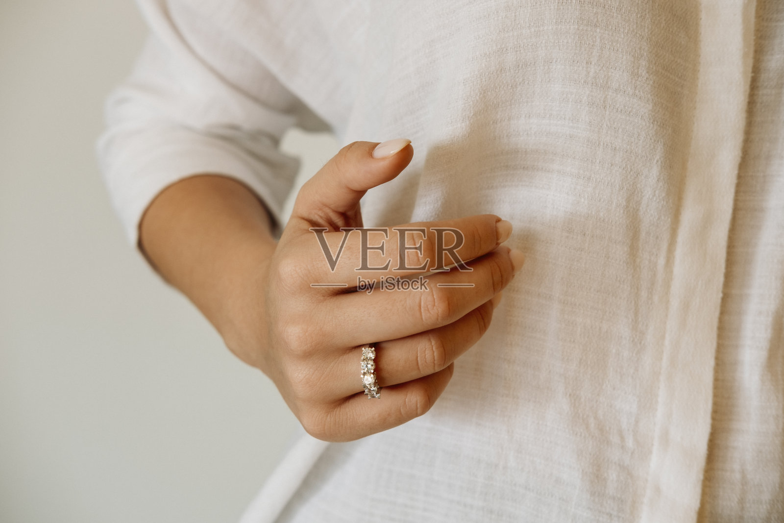 年轻女子的手上戴着一枚钻石戒指。新娘的结婚饰物。照片摄影图片