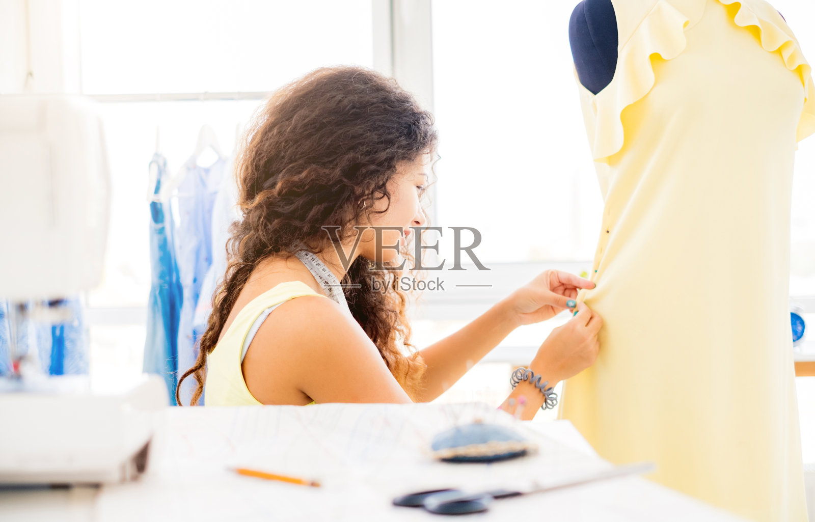 女裁缝把别针放进衣服里照片摄影图片