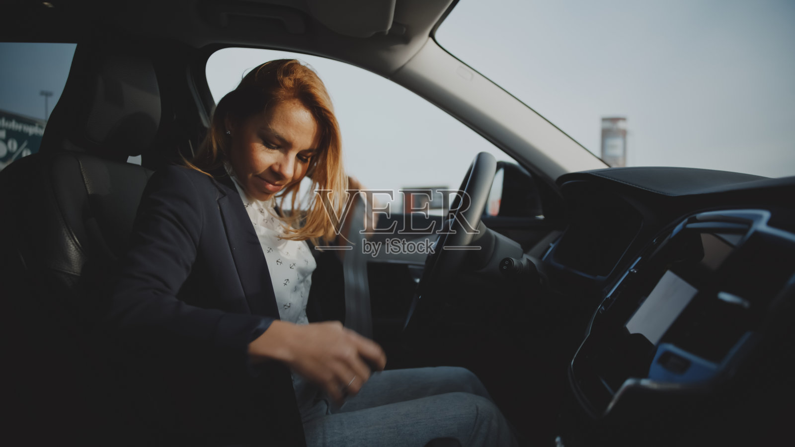 女商人坐在司机座位上系安全带照片摄影图片