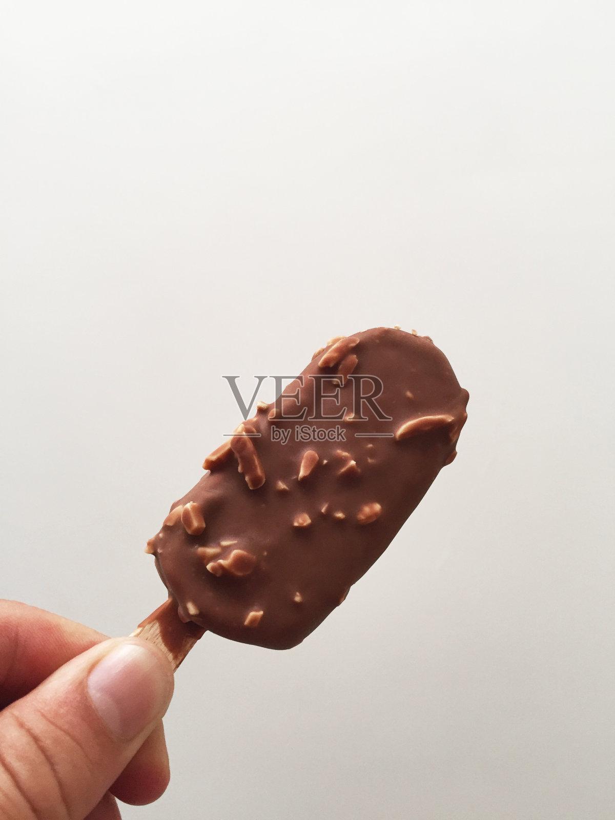 手握巧克力杏仁雪糕照片摄影图片