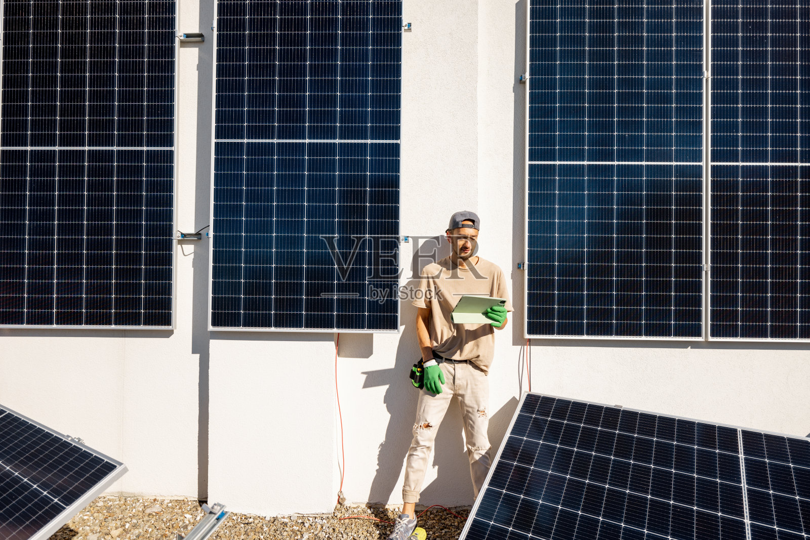 技术人员在太阳能发电站的屋顶上拿着数字平板电脑照片摄影图片