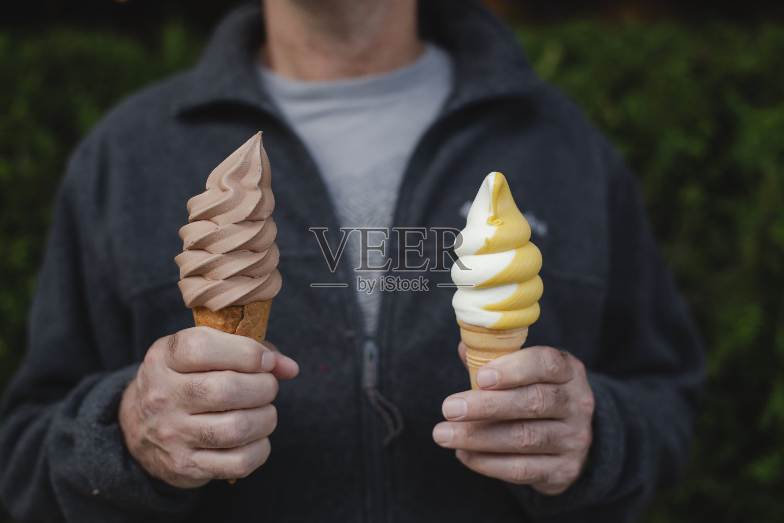 一个拿着两个冰淇淋蛋筒的男人照片摄影图片