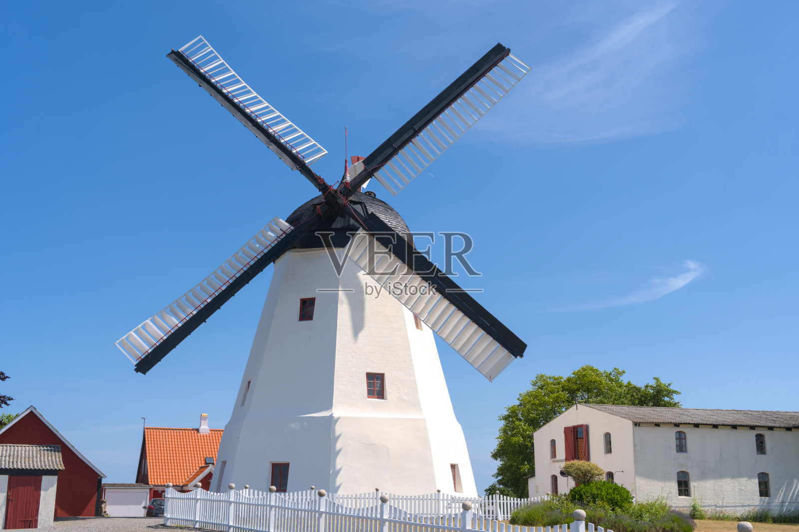 一个美丽的古老的白色风车在阿斯代尔，博恩霍尔姆在一个晴朗的蓝天照片摄影图片