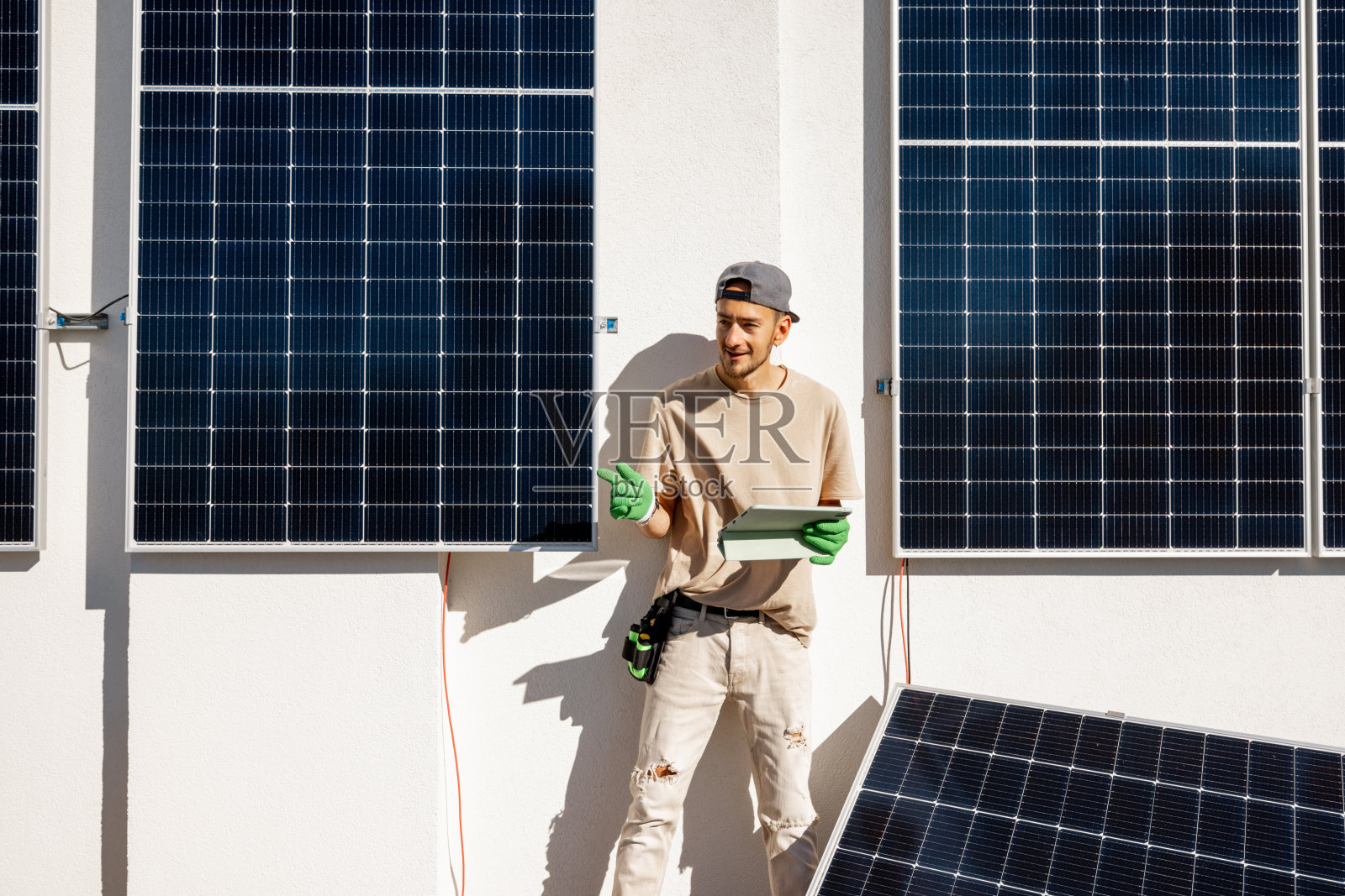 技术人员在太阳能发电站的屋顶上拿着数字平板电脑照片摄影图片