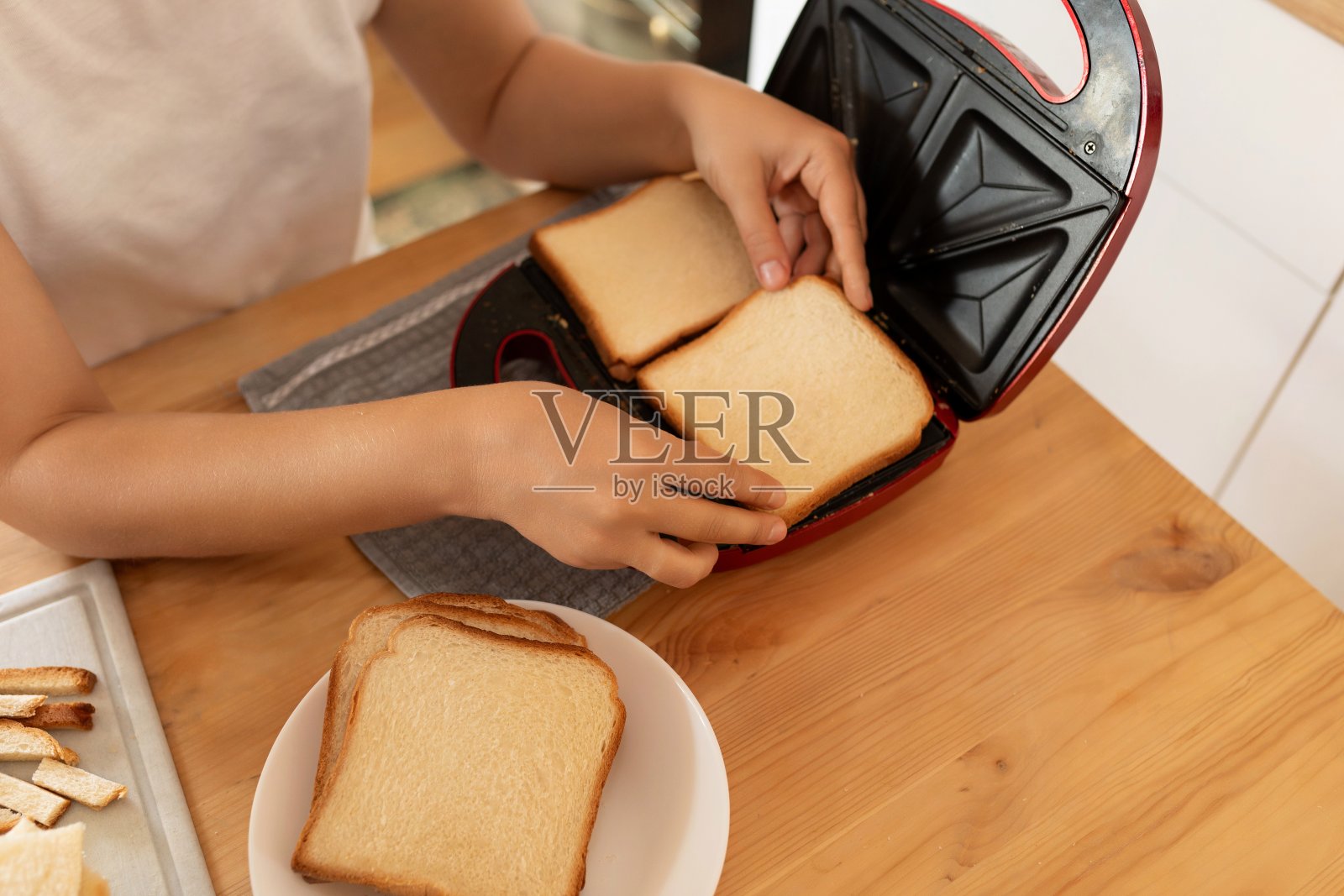 一位妇女在厨房的烤箱里烤面包照片摄影图片