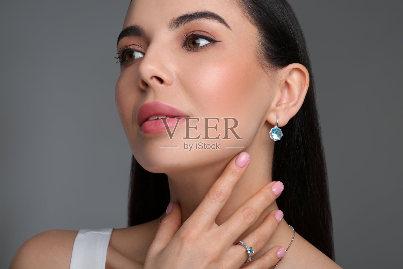 美丽的年轻女子与优雅的珠宝在深灰色的背景照片摄影图片