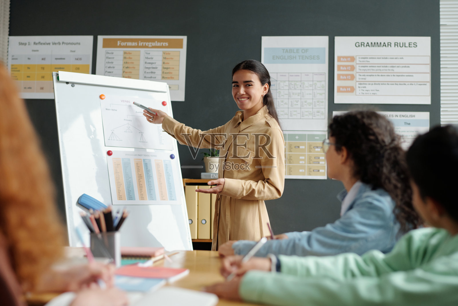 年轻成功的老师指着白板，解释新的信息照片摄影图片