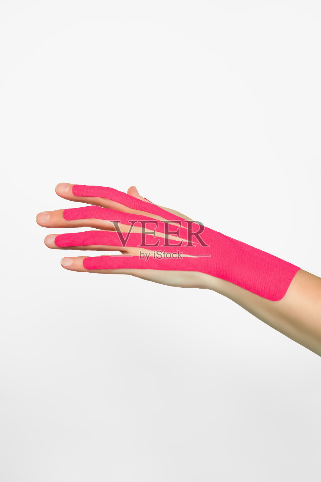 美观的手工胶带。女性的手贴着粉红色的肌内效贴。手部皮肤护理，非手术手部皮肤收紧使用肌内效胶带照片摄影图片