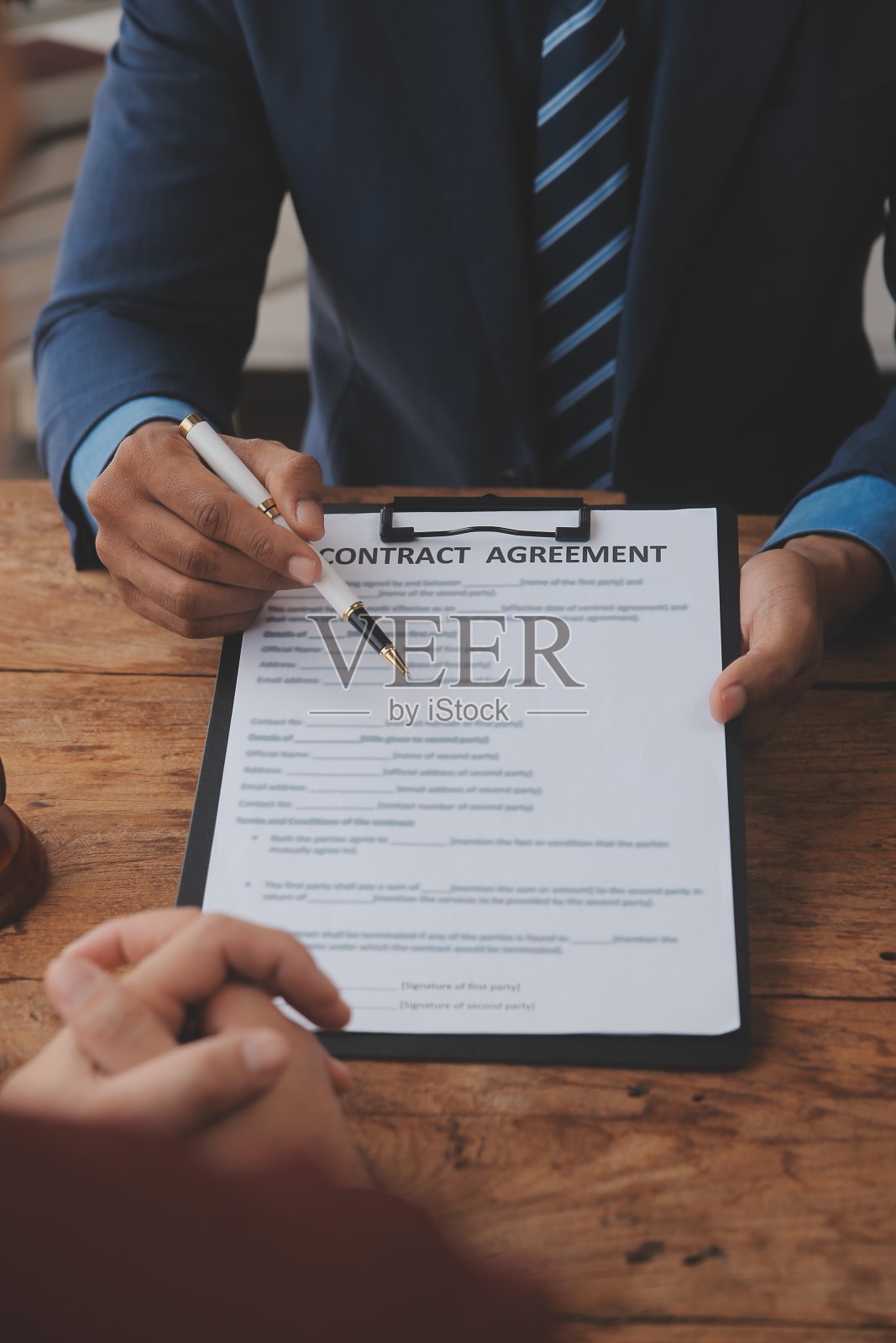 正义与法律概念。法律顾问在后台用木槌和法律或法律团队会议向客户出示签署的合同照片摄影图片