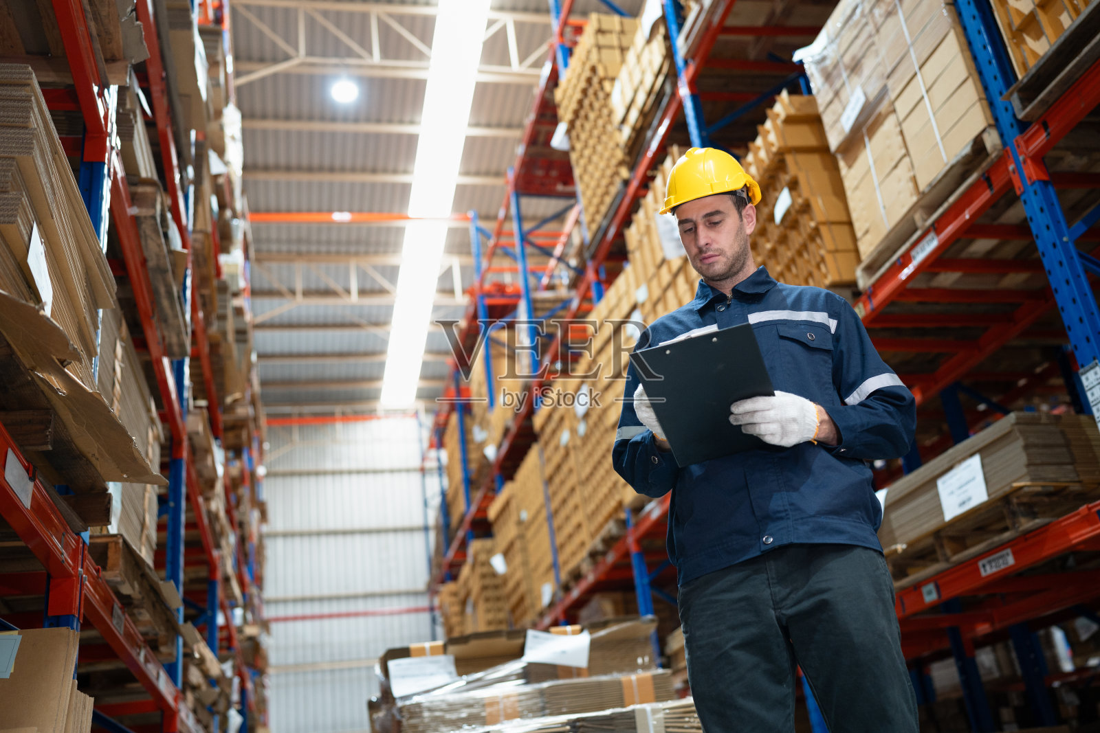 白人商人工人使用剪贴板检查仓库中的牛皮纸库存照片摄影图片