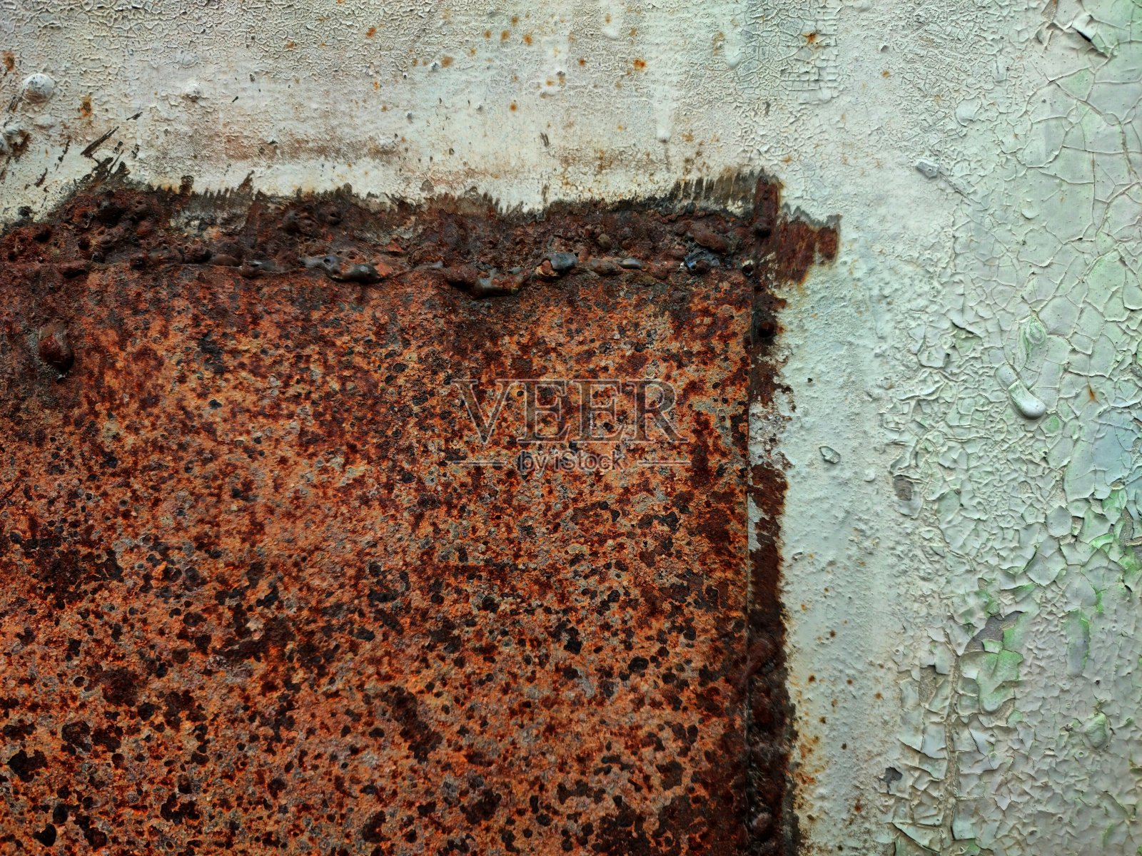 金属墙涂着旧灰漆和一块生锈的金属照片摄影图片