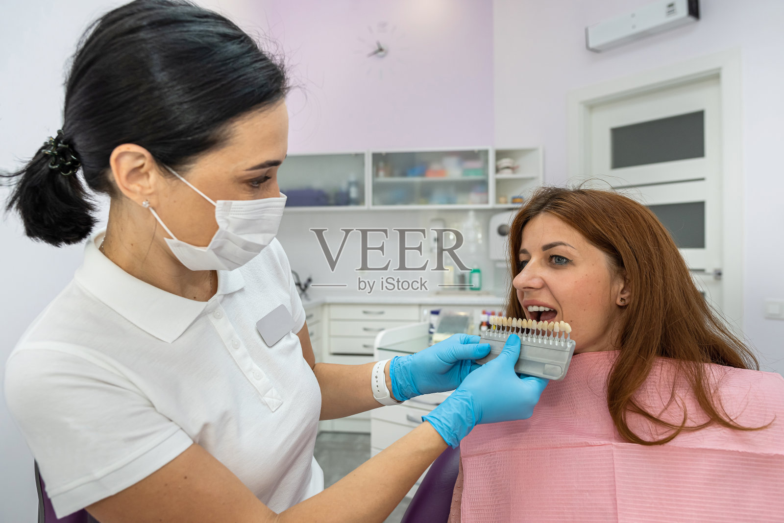 一位美丽的年轻女子正在牙科诊所接受牙齿治疗和检查。照片摄影图片