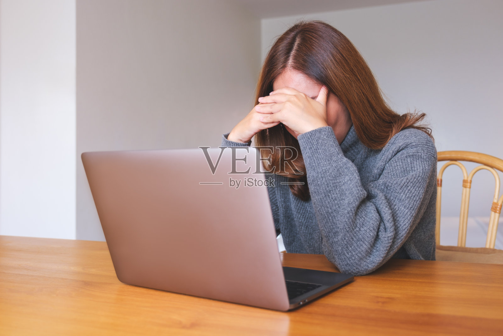 一个女人在家里用笔记本电脑上网时感到头痛和压力照片摄影图片